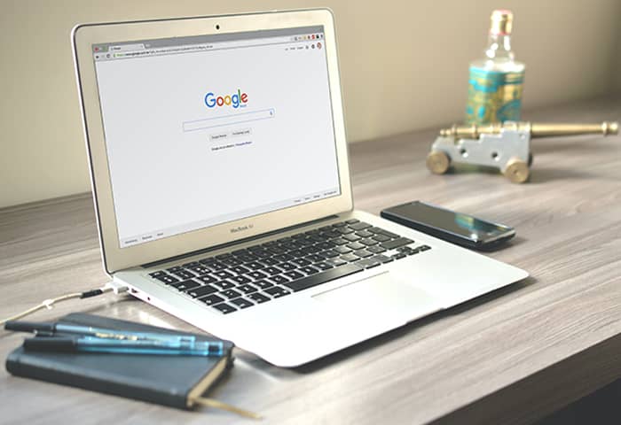 A laptop on a desk with the Google homepage