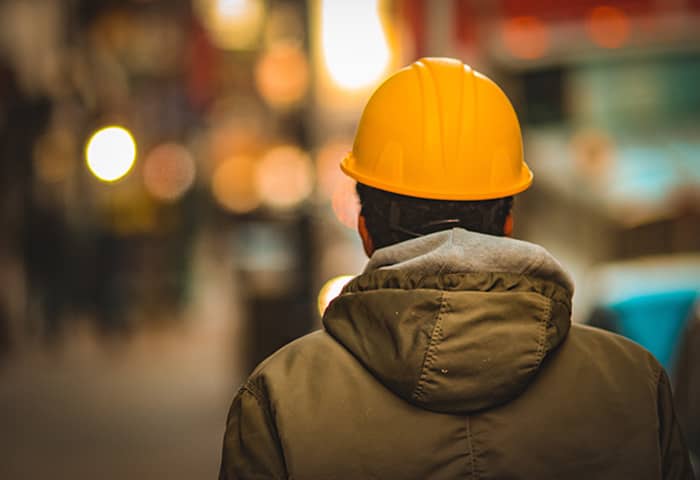A man wearing a yellow safety helmet in the street